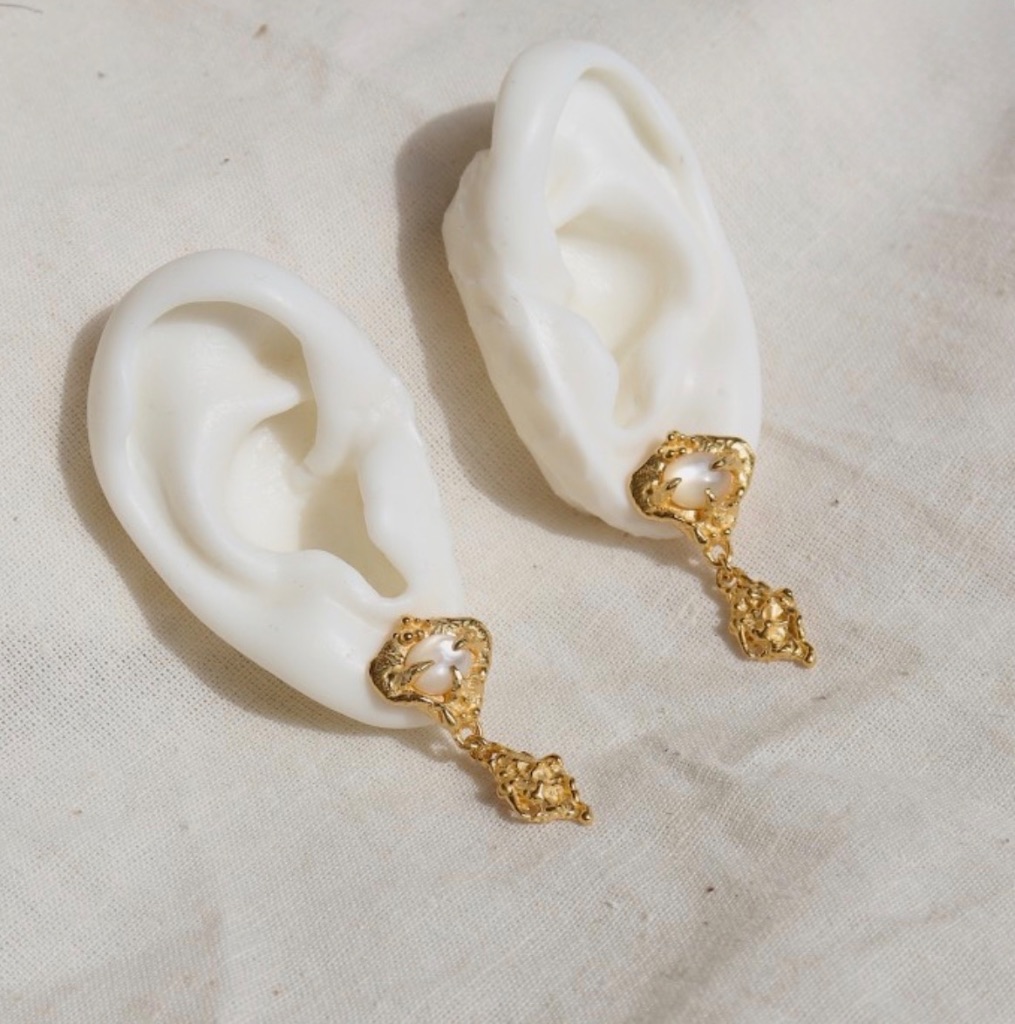 Gilded Tide Pearl Earrings on ear mold